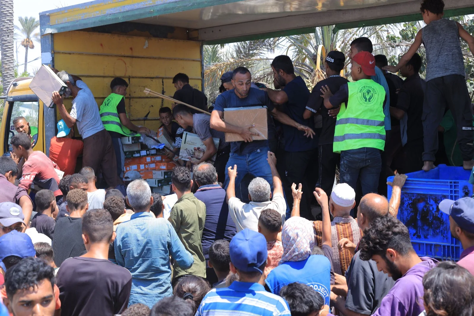 Aid teams distributing food to a large crowd in Gaza